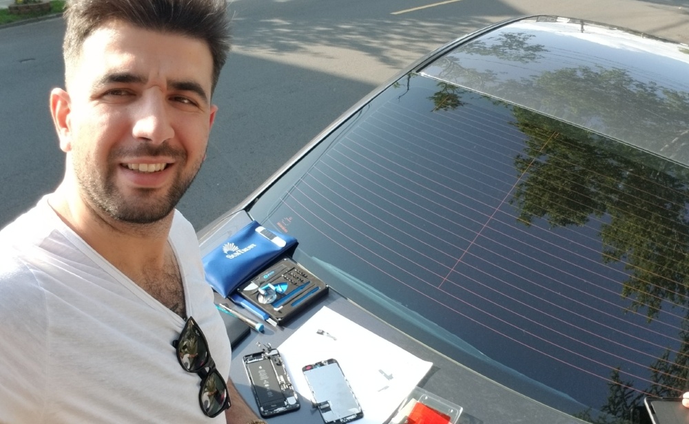 technician Ayhan Sagir repairing a phone on a car